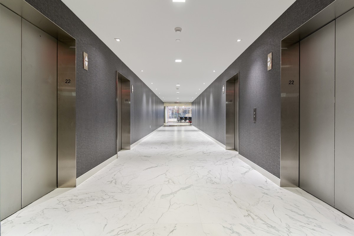 Elevator lobby on floor 22 with dark gray walls, marble flooring, and stainless doors